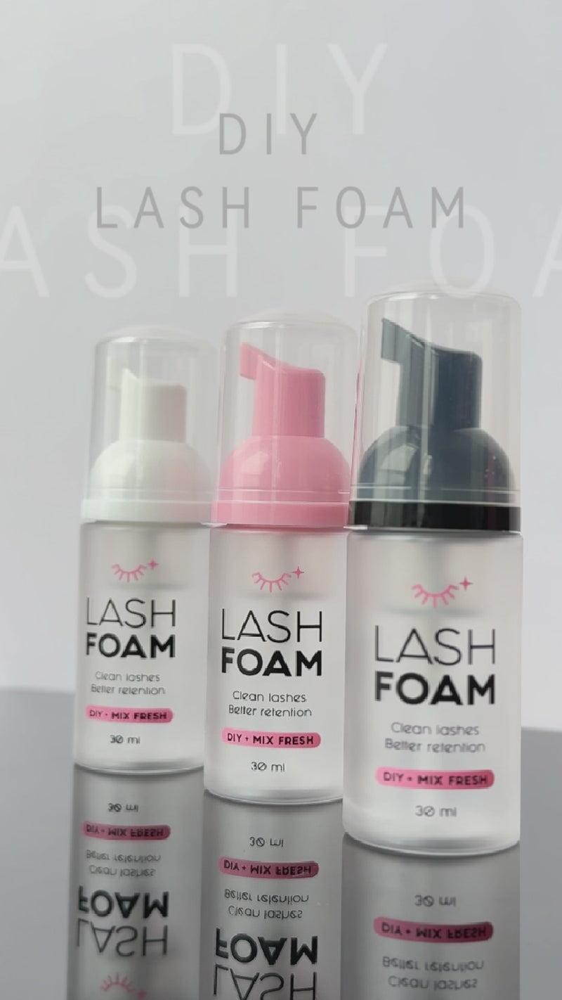 Drei EngelsWimpern DIY Lash Foam Flaschen mit heller, rosafarbener und schwarzer Schaumpumpe vor grauem Hintergrund.
